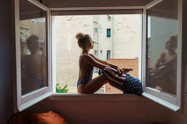 Kvinna på fönsterbrädan med kudde — Stockfoto