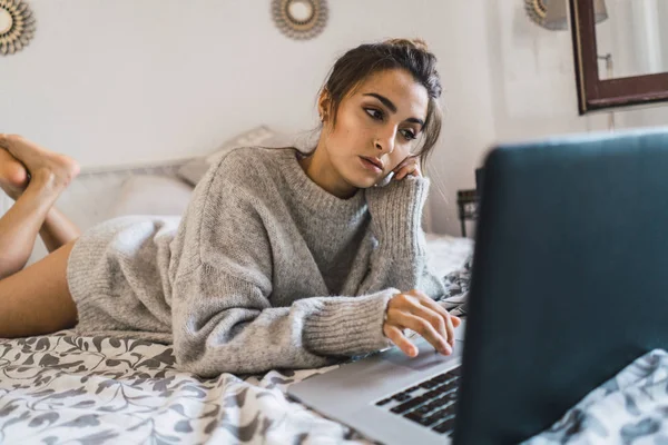 Kobieta w łóżku przeglądanie laptopa — Zdjęcie stockowe
