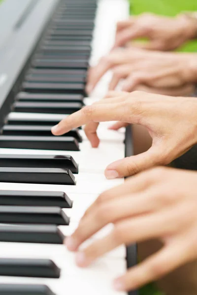 Люди грають на фортепіано чотири руки — стокове фото