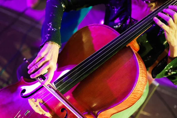 Жінка в вечірній сукні грає на басовій скрипці Стокове Зображення