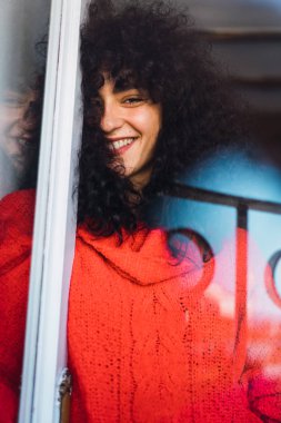 Pencerenin arkasında gülümseyen kadın