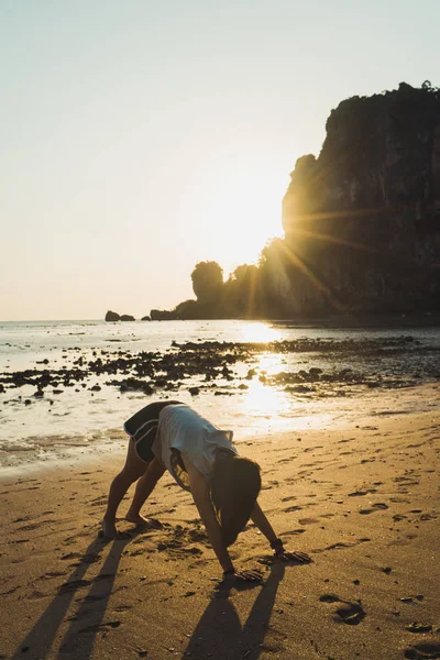 Mujer estirándose en la playa de arena — Foto de Stock