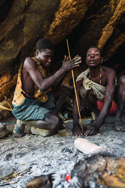 Eyasi lake, Tanzania, november, 23, 2019: two African hunters preparing fire — Stock Photo, Image