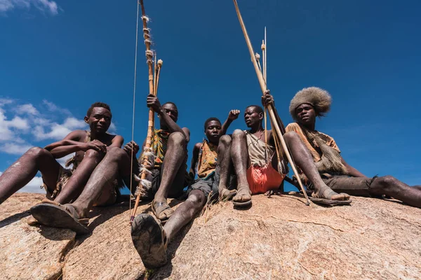 Eyasi lake, Tanzania, november, 23, 2019: African hunters sitting on a rock — Stock Photo, Image
