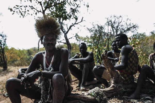 Eyasi lake, Tanzania, november, 23, 2019: African hunters sitting on the savannah — Stock Photo, Image
