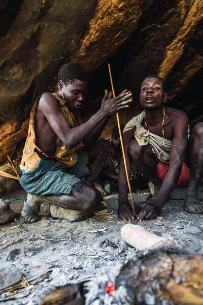 Eyasi lake, Tanzania, november, 23, 2019: two African hunters preparing fire Stock Image