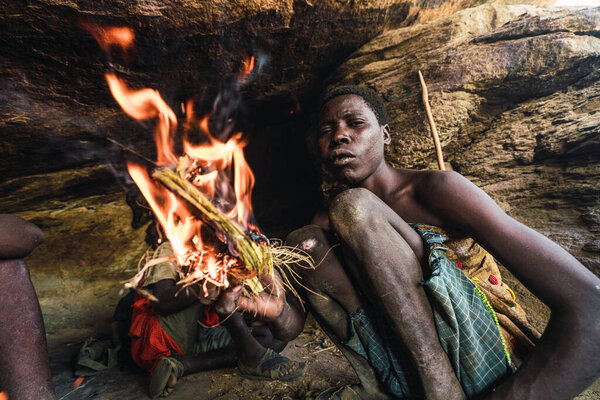 Eyasi lake, Tanzania, november, 23, 2019: African hunter preparing fire Royalty Free Stock Photos