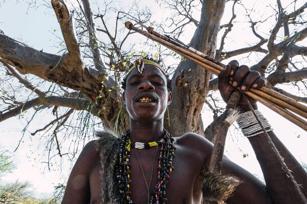 Eyasi lake, Tanzania, november, 23, 2019: African hunter with jewellery and coloured ornaments Stock Picture