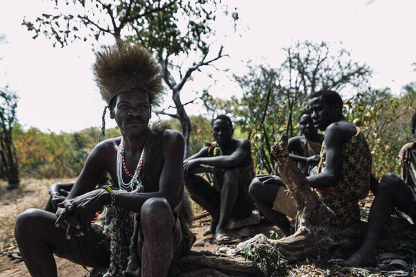 Eyasi lake, Tanzania, november, 23, 2019: African hunters sitting on the savannah Stock Image