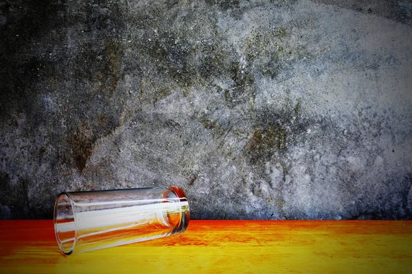 Glas på trä bordet framför cement väggen — Stockfoto