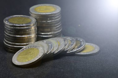 Tay siyah arka plan üzerinde para sikke.