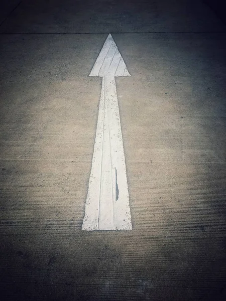 White arrow symbol on the road
