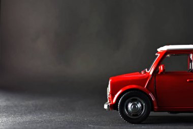 Neredeyse siyah renkli bir katta küçük bir kırmızı araba