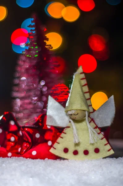 Bebek melek bir bulanık ağaç ve şenlikli aydınlatma çerçevede karda