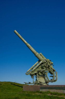 Mavi gökyüzü arka plan üzerinde bir granit kaide üzerinde uçaksavar topu