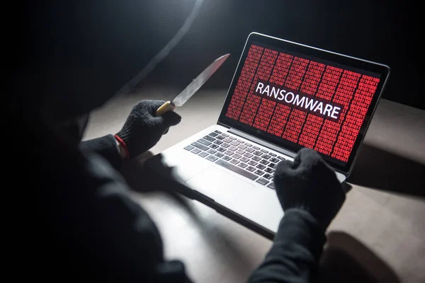 Hombre hacker threading ordenador portátil con cuchillo — Foto de Stock