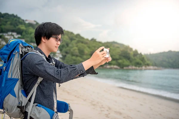 Fiatal ázsiai hátizsákos fényképeket a smartphone — Stock Fotó