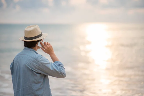 Tânărul vorbeşte la telefon şi vede apusul soarelui. — Fotografie, imagine de stoc