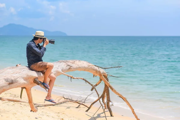 A fiatalember fotós fotózni a strandon — Stock Fotó