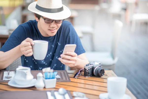 Jonge Aziatische man met behulp van slimme telefoon tijdens het ontbijt — Stockfoto