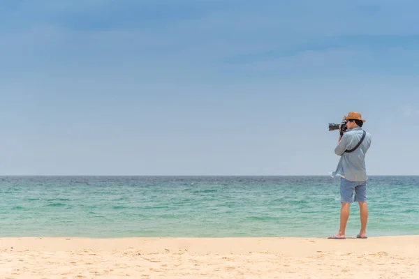 Jeune homme photographe prendre des photos sur la plage — Photo