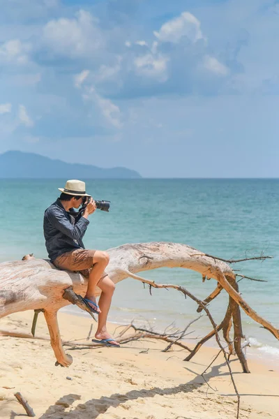 Młody człowiek fotografa robić zdjęcia na plaży — Zdjęcie stockowe