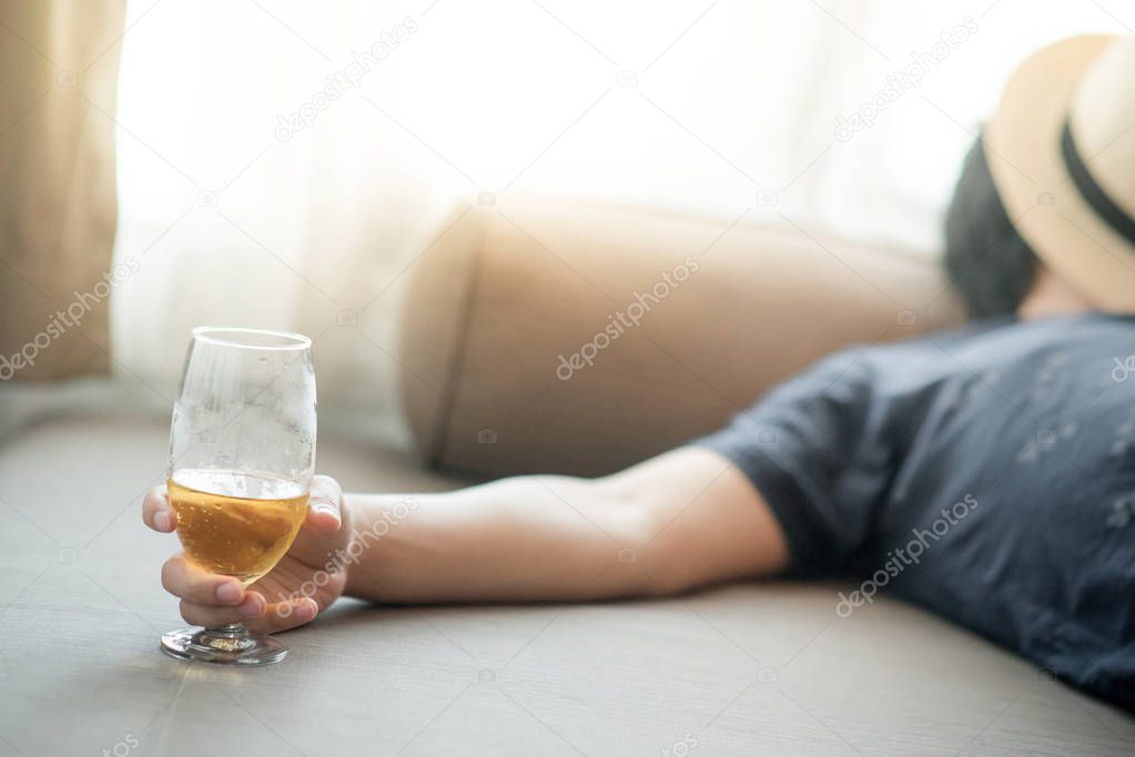 drunken man sleeping while holding a glass of beer