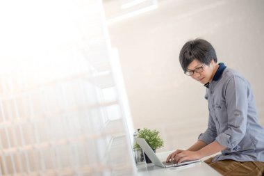 Genç Asyalı adam kafede dizüstü bilgisayar ile çalışma