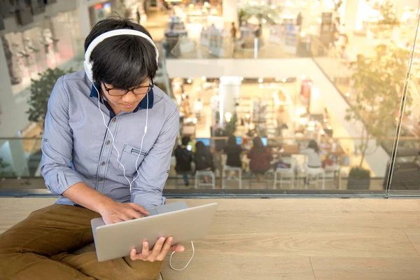 음악을 듣는 동안 노트북으로 작업 하는 젊은 아시아 남자 — 스톡 사진