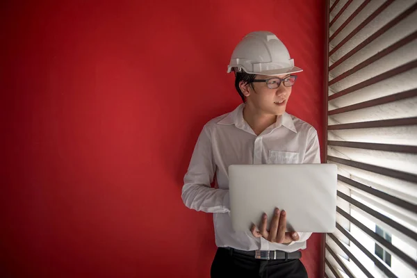 Ingenjör som arbetar med laptop i röda byggnaden utrymme — Stockfoto