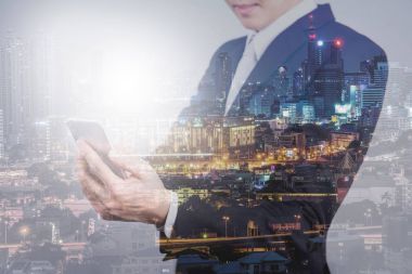 Smartphone ve gece şehir görünümünü kullanarak iş adamı