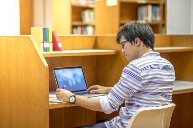 Genç Asyalı Üniversite öğrenci Kitaplığı'nda