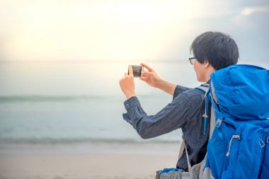 Genç Asyalı backpacker smartphone ile fotoğraf çekmek