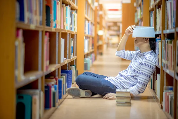 Jonge Aziatische universiteitsstudent in bibliotheek — Stockfoto
