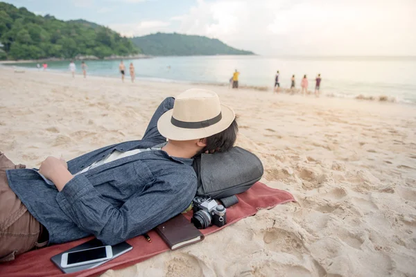 Fiatal ázsiai férfi feküdt a tengerparton — Stock Fotó