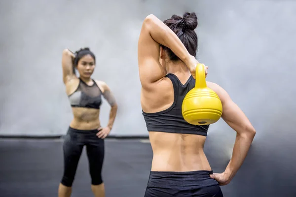 Joven asiática fitness femenino ejercicio con hervidor de agua campana — Foto de Stock