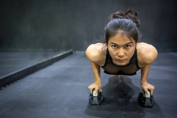 Jonge Aziatische atleet vrouw doet duw omhoog op de vloer — Stockfoto