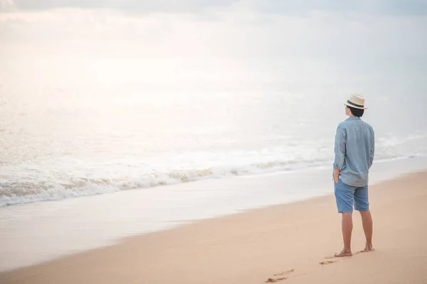 Fiatal ázsiai ember keresi a naplemente a strandon — Stock Fotó