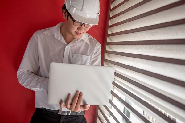 Ingenjör som arbetar med laptop i röda byggnaden utrymme — Stockfoto