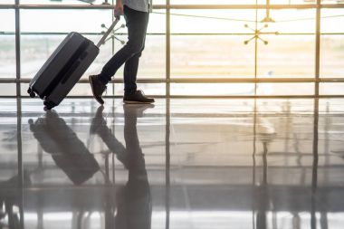 Havaalanı Bagaj ile terminal içinde yürüyen adam
