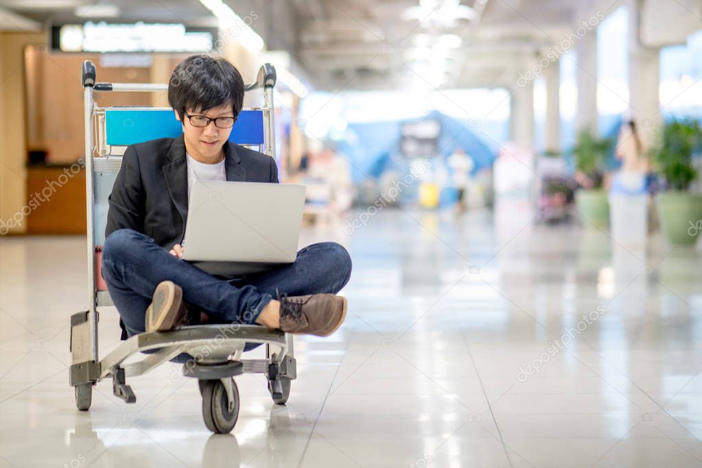 Young asian man working on airport trolley