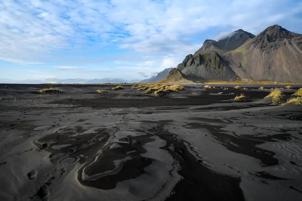 Mountains and volcanic lava sand in Stoksness, Iceland — стоковое фото