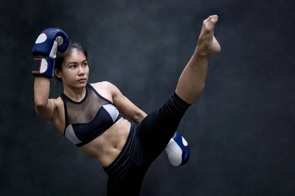 Jovem mulher asiática boxer com luvas de boxe chutando — Fotografia de Stock