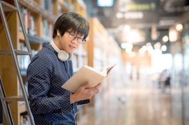 Genç Asyalı Üniversite öğrenci Kitaplığı'nda