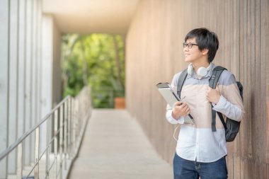 Dosya ve laptop üniversitede tutan genç Asyalı adam