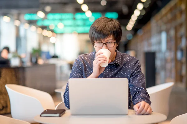 Fiatal ázsiai ember dolgozik a laptop-ban könyvtár — Stock Fotó