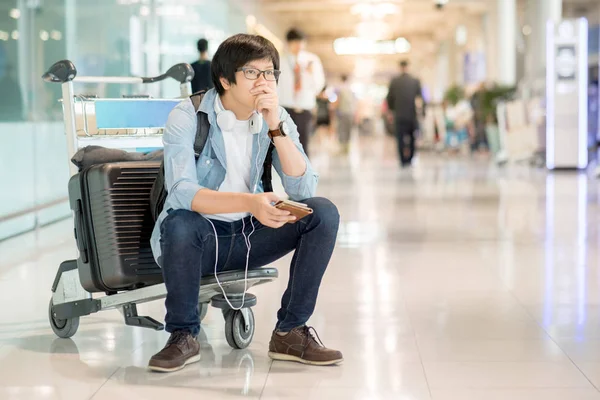Joven asiático sentirse agotado en la terminal del aeropuerto — Foto de Stock