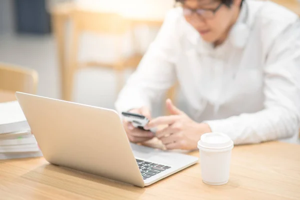 Joven hombre de negocios asiático trabajando en una cafetería — Foto de Stock