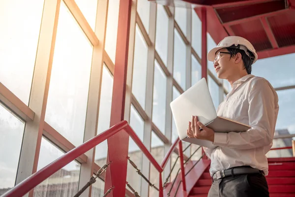 Ung asiatisk ingenjör eller arkitekt som arbetar med laptop — Stockfoto