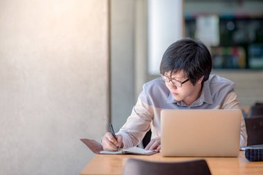 Genç Asyalı adam üniversite içinde laptop ile çalışma